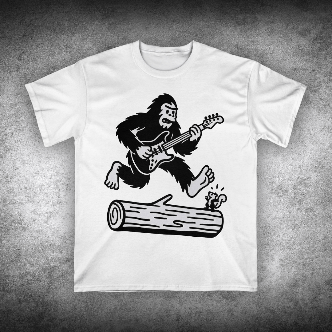 White t-shirt with a graphic of a gorilla playing guitar on a concrete surface