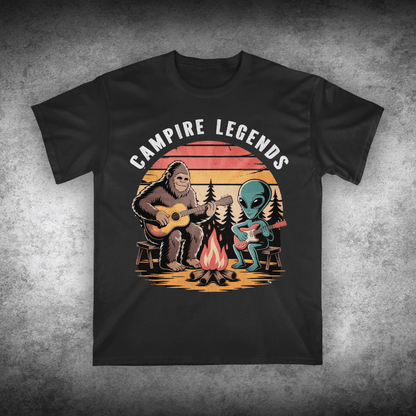 Black t-shirt with 'Campire Legends' graphic featuring a bear and alien by a campfire on a textured gray background.