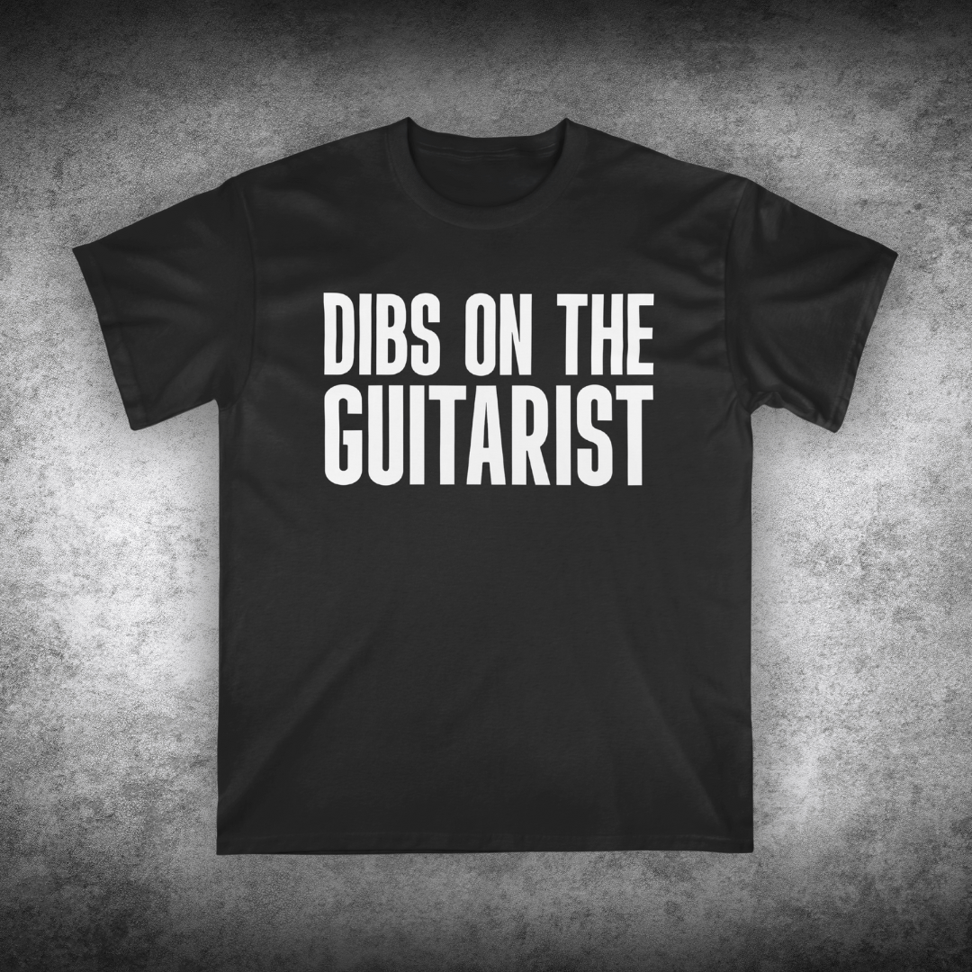 Black t-shirt with 'DIBS ON THE GUITARIST' text on a textured gray background