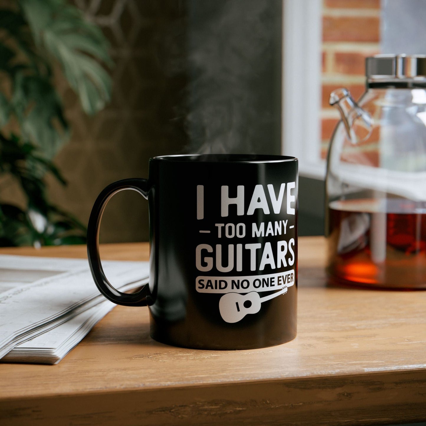 Black mug with guitar-themed text on a wooden surface
